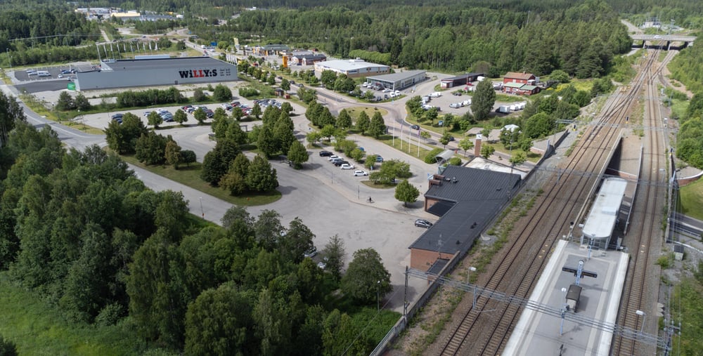 En flygbild av en tågstation och omgivande träd.